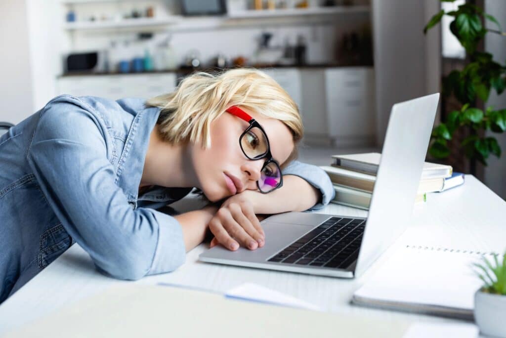bored woman lying on her computer