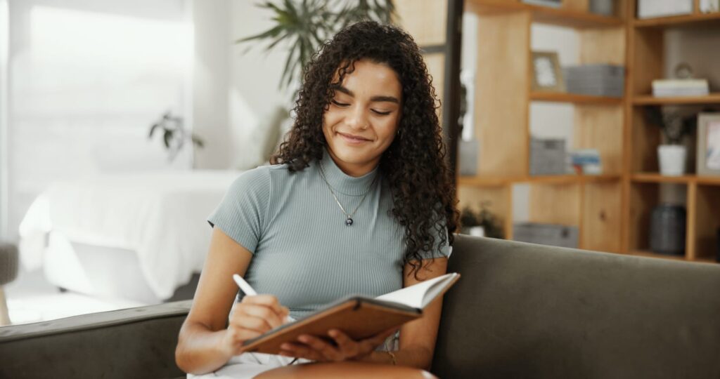 girl journalling on the couch