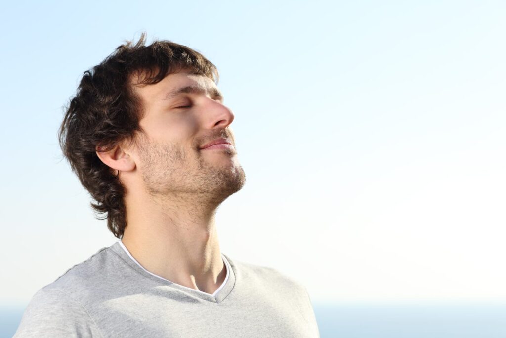 closeup of man breathing deeply outside