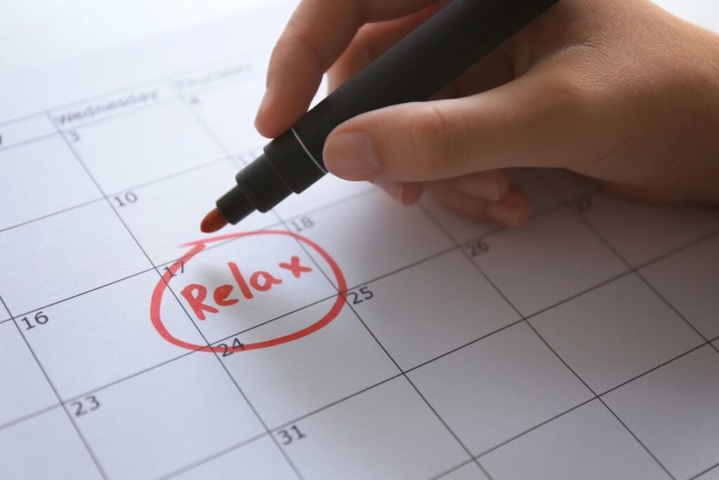 person writing relax word on calendar