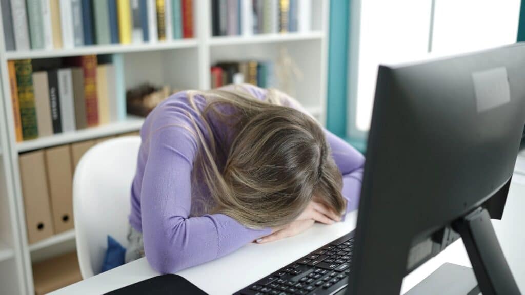 stressed young woman with head on laptop keyboard